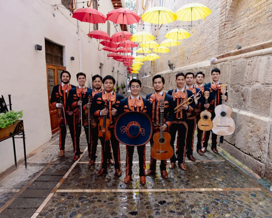 Mariachi Tabasco completo con sus instrumentos en una calle adornada con paraguas