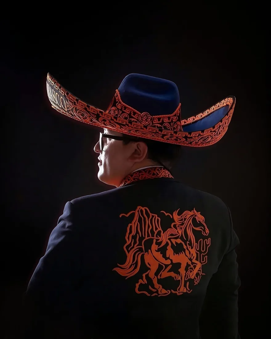 El Patrón Cuenca de espaldas con su sombrero y el caballo bordado en el traje